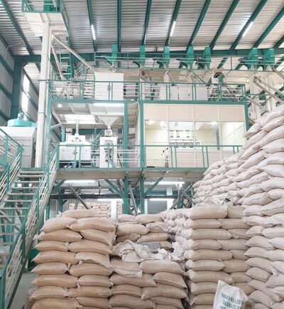 Rice processing equipment and stacked rice bags inside a mill