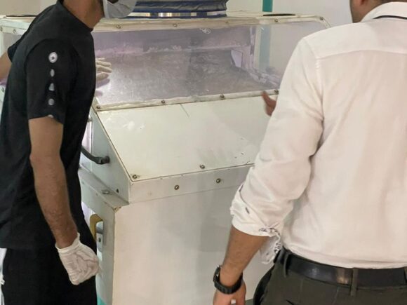 Rice mill staff inspecting production equipment